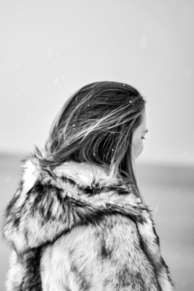 Picture is showing Jessica covered in a winter coat facing the freezing cold atlantic ocean